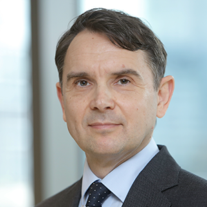 Chris Gower, professional headshot in office setting with window light and blurred background