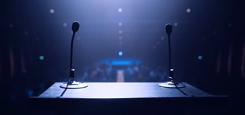 Two microphones on stage with spotlight.